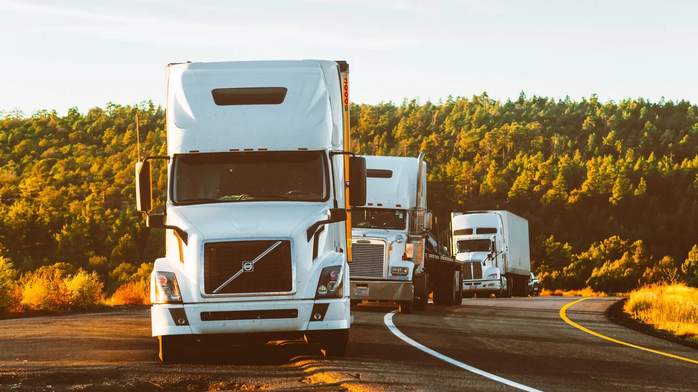 White semi trucks parked on a rural road